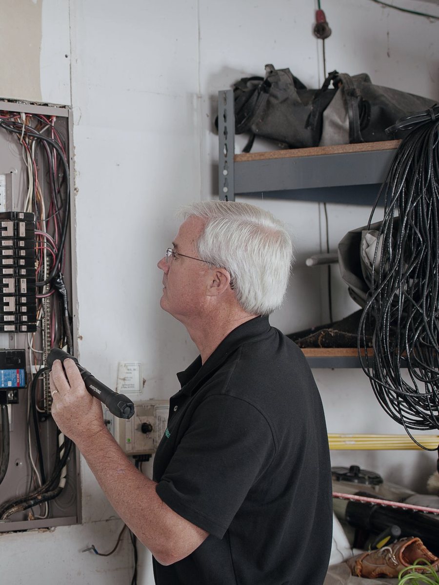 An electrician inspecting a household panel
